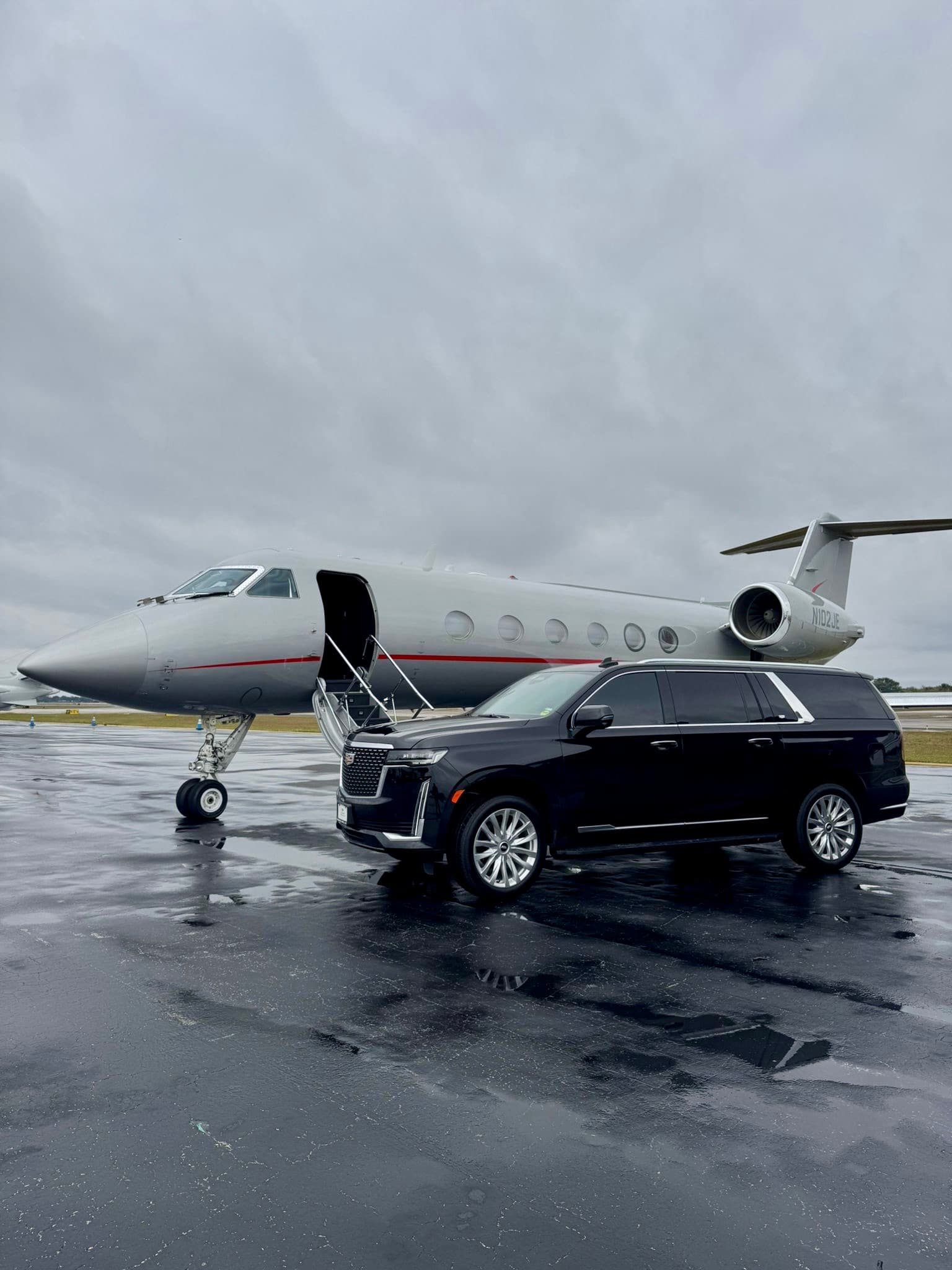 A black Escalade waiting beside a private jet on the tarmac